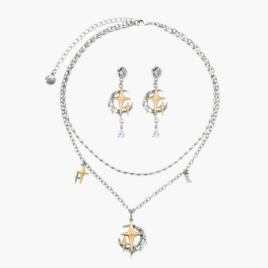 Delicate eco-brass jewelry set featuring gold star and silver moon crescents with clear zirconia crystal drops on cream background