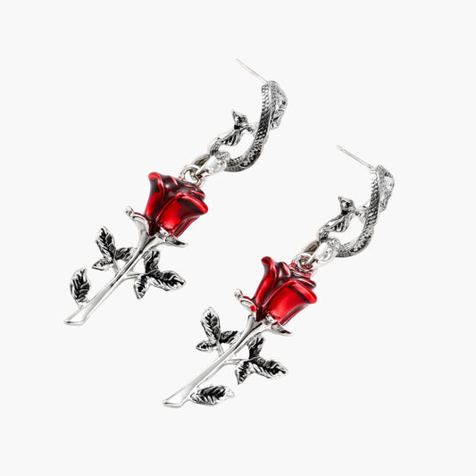 Gothic dangle earrings featuring silver serpent hooks with red enamel roses and metallic stems on white background.