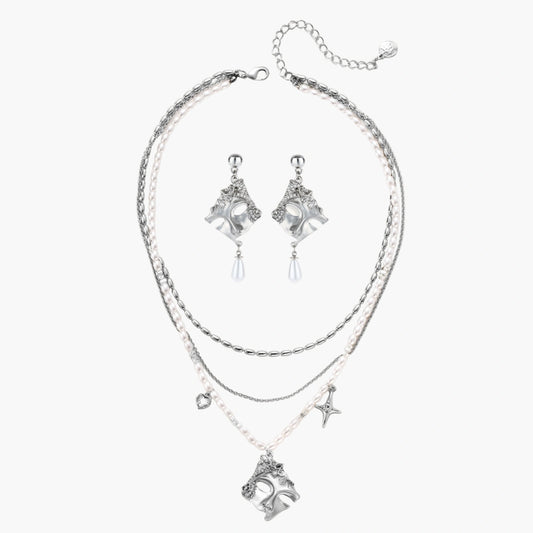 Ornate silver-toned masquerade mask jewelry set featuring rhinestone details and pearl drop earrings on white background.