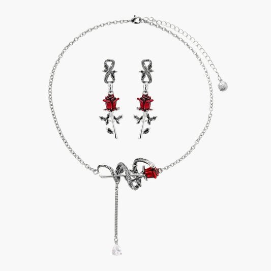 Gothic jewelry set with silver snake designs holding red enamel roses, featuring detailed leaf stems on cream background