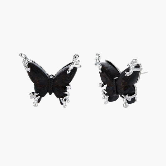 Dark wood butterfly earrings and necklace with silver chain accents on white background, showing natural grain texture.