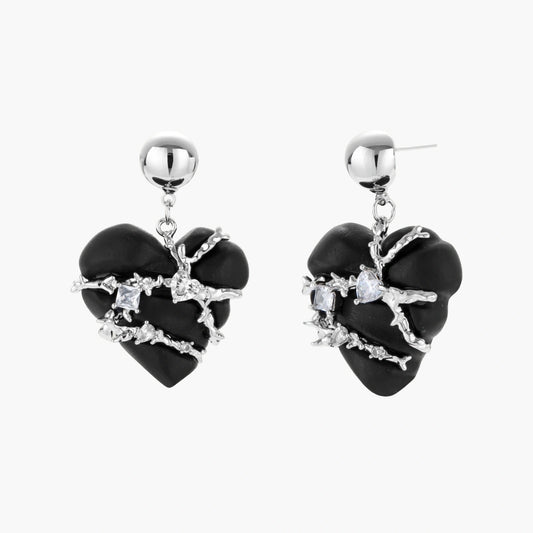 Dark ebony wood heart charms wrapped in intricate silver chains with crystal accents, shown as matching earrings and necklace set.