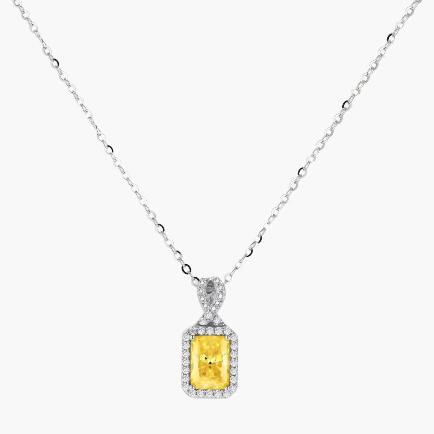 Yellow moissanite jewelry set with emerald-cut stones in sterling silver halo settings on white background.