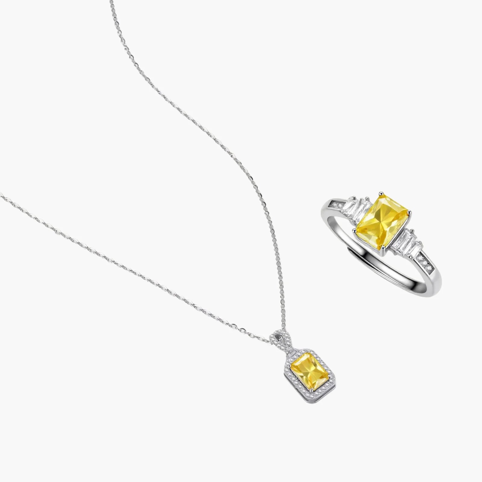 Yellow moissanite jewelry set with emerald-cut stones in sterling silver halo settings on white background.