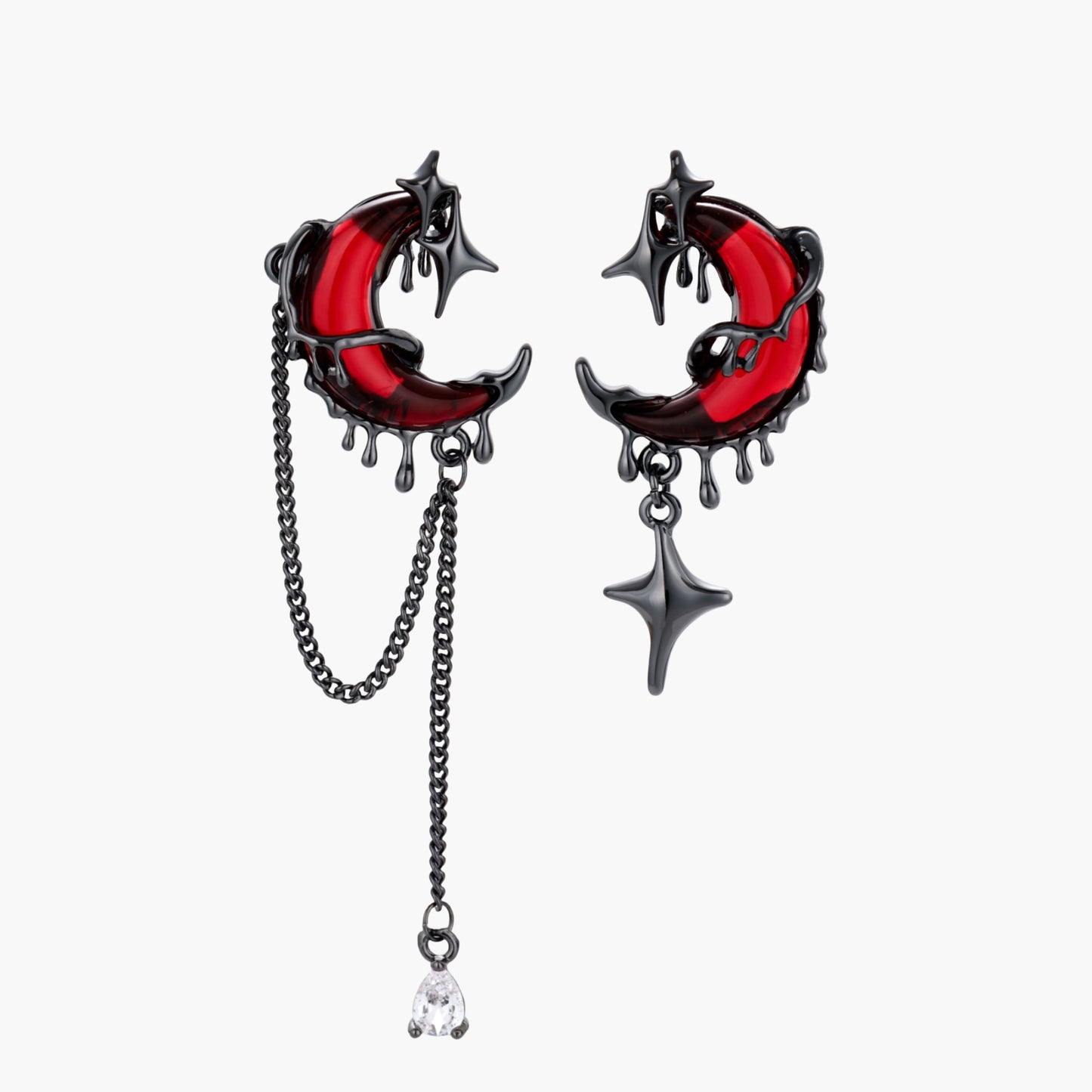 Gothic asymmetrical earrings with red crescent moons, black dripping stars, chains and crystal drop on white background.