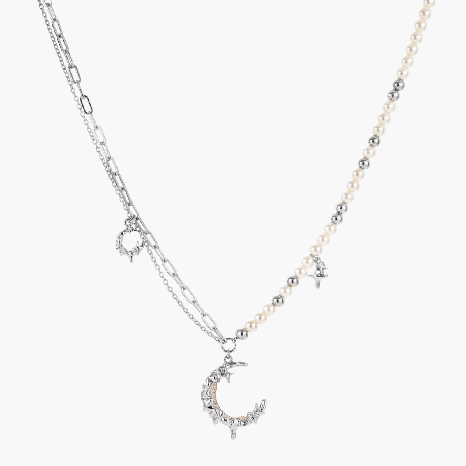 Silver-toned crescent moon pendant with star accents on pearl and chain necklace against white background.