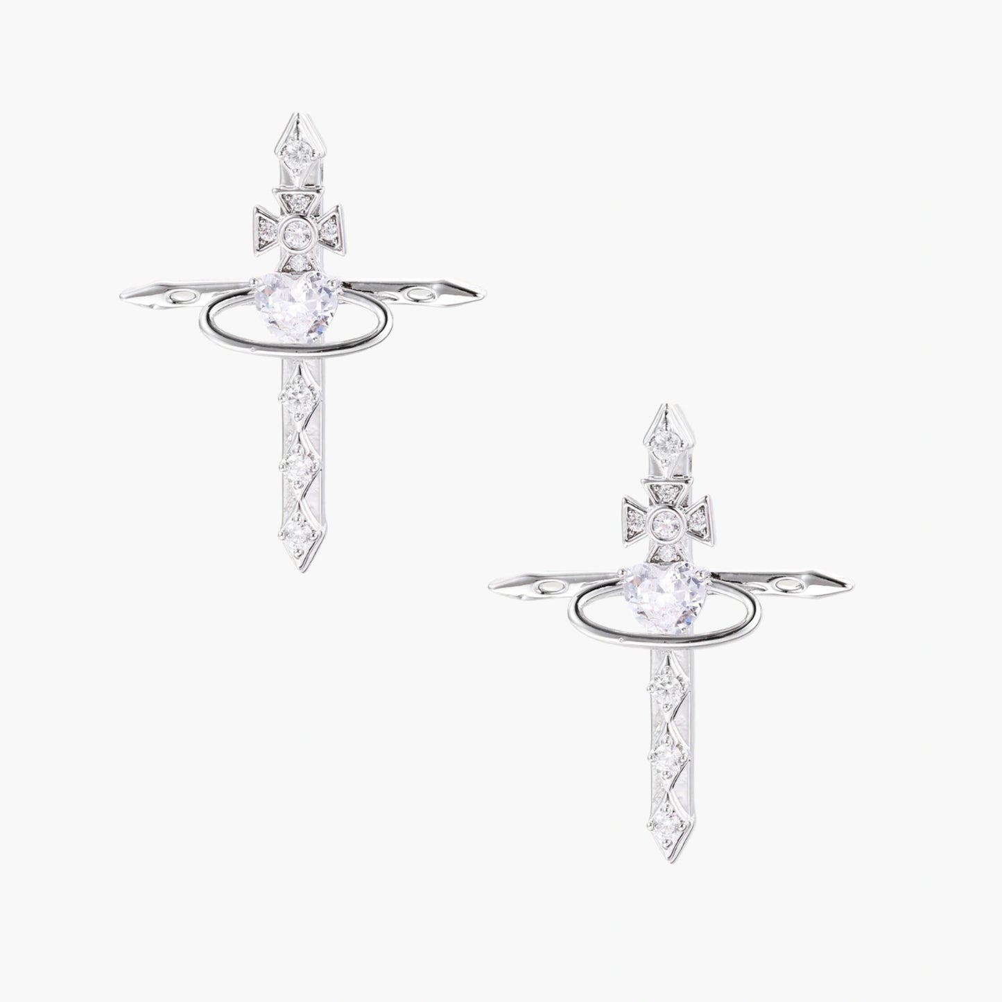 White gold plated cross earrings with orbital ring & zirconia stones on cream background