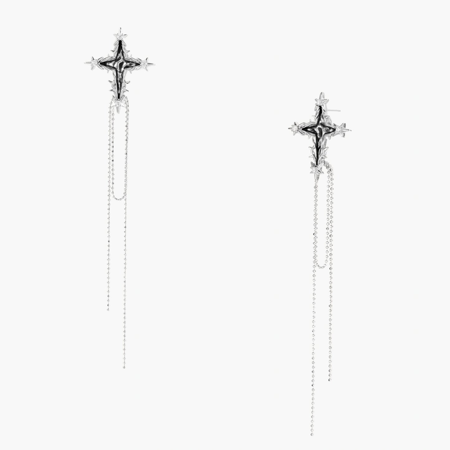 Long silver threader earrings with ornate cross-star design and delicate dual chain tassels on white background