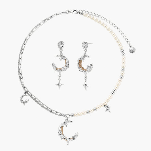 Mixed-metal jewelry set featuring layered necklaces with crescent moon pendant and pearl beads, plus matching star-drop earrings.