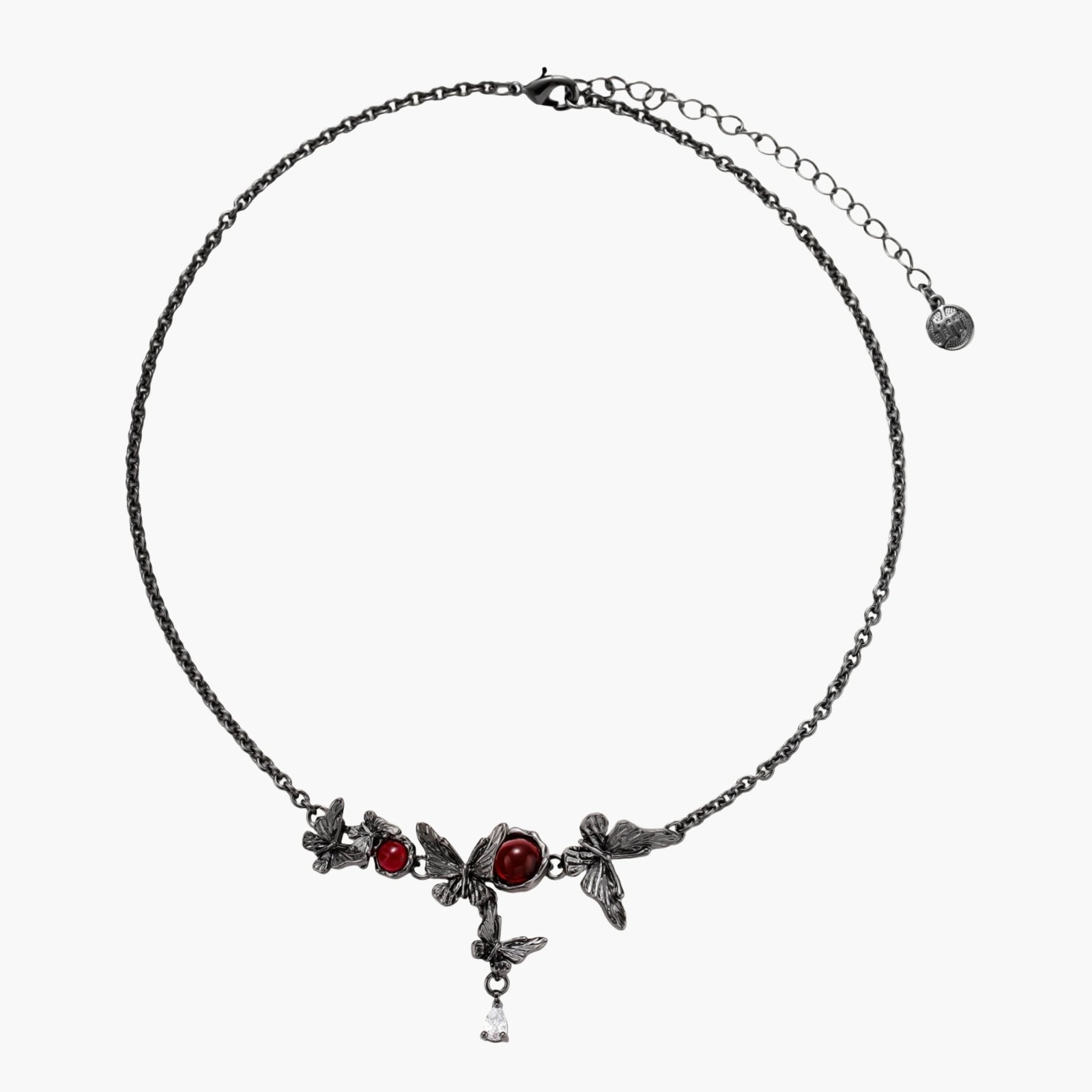 Dark oxidized metal necklace featuring red resin stones set in decorative leaf vine design with crystal drop pendant.