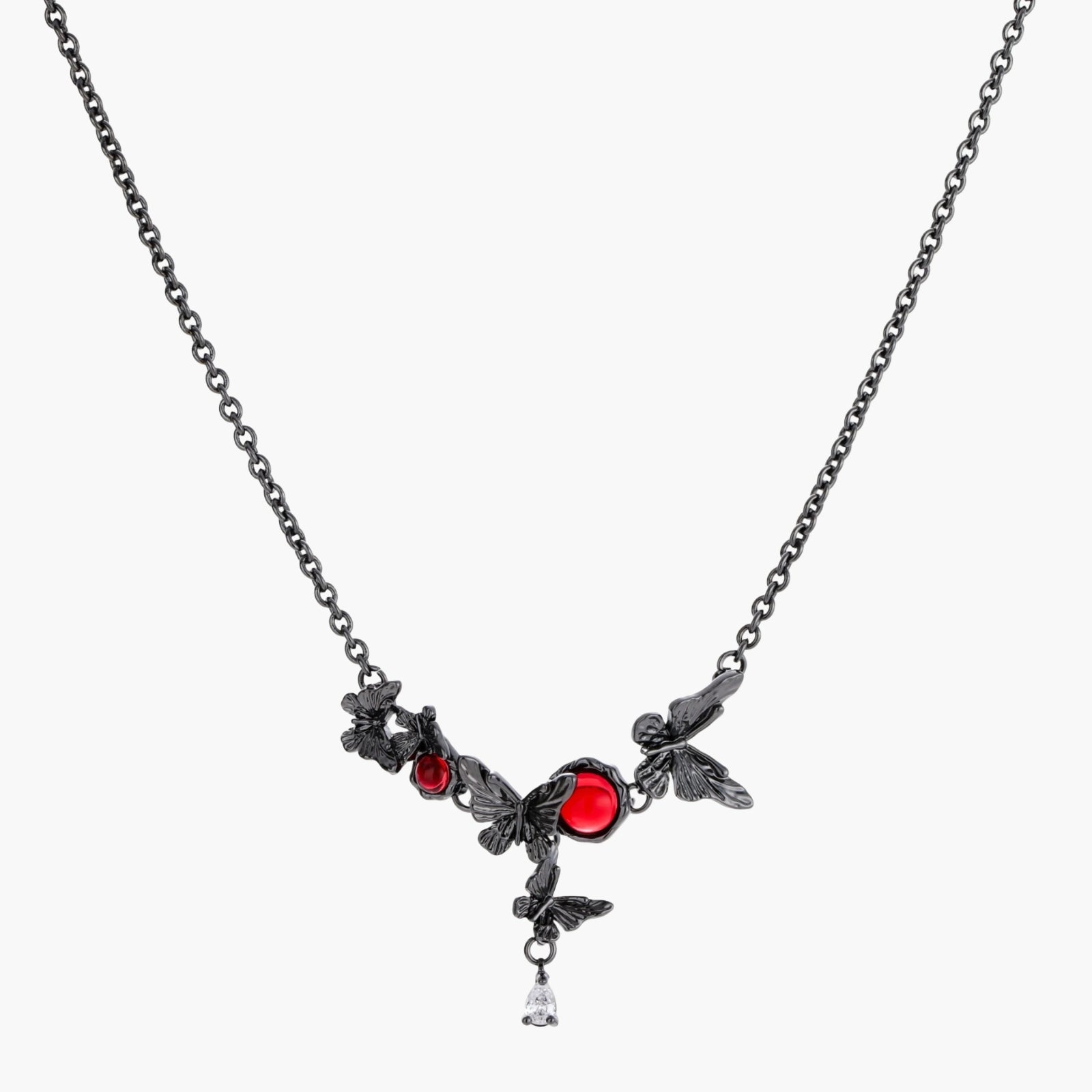 Dark oxidized metal necklace featuring red resin stones set in decorative leaf vine design with crystal drop pendant.