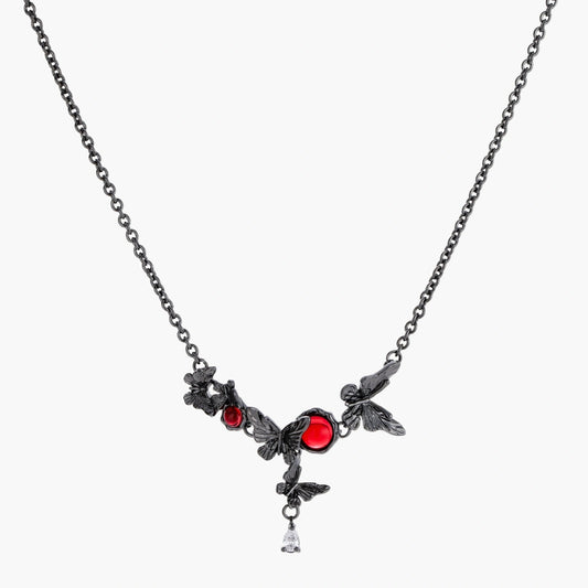 Dark oxidized metal necklace featuring red resin stones set in decorative leaf vine design with crystal drop pendant.