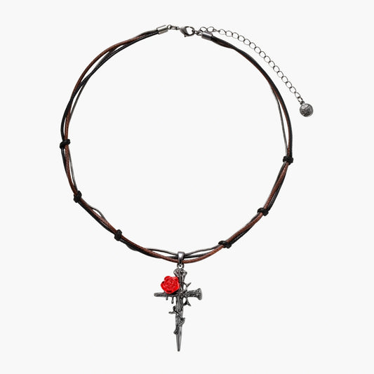 Gothic cross pendant with red enamel rose and thorn details on adjustable brown cord necklace against white background.