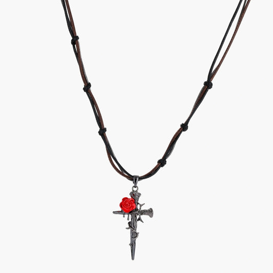 Gothic cross pendant with red enamel rose and thorn details on adjustable brown cord necklace against white background.