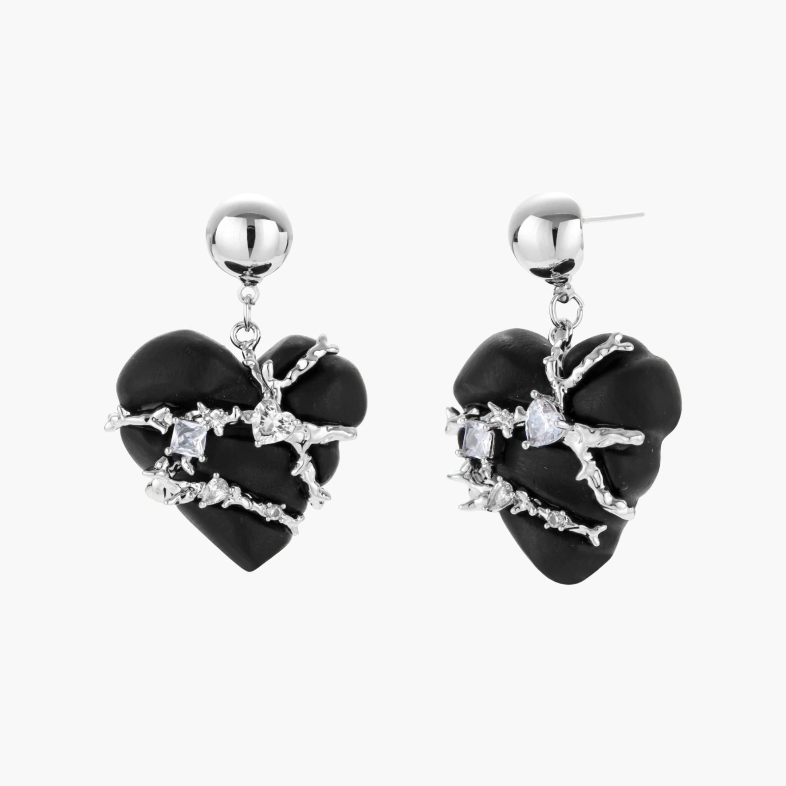 Dark ebony wood heart charms wrapped in intricate silver chains with crystal accents, shown as matching earrings and necklace set.