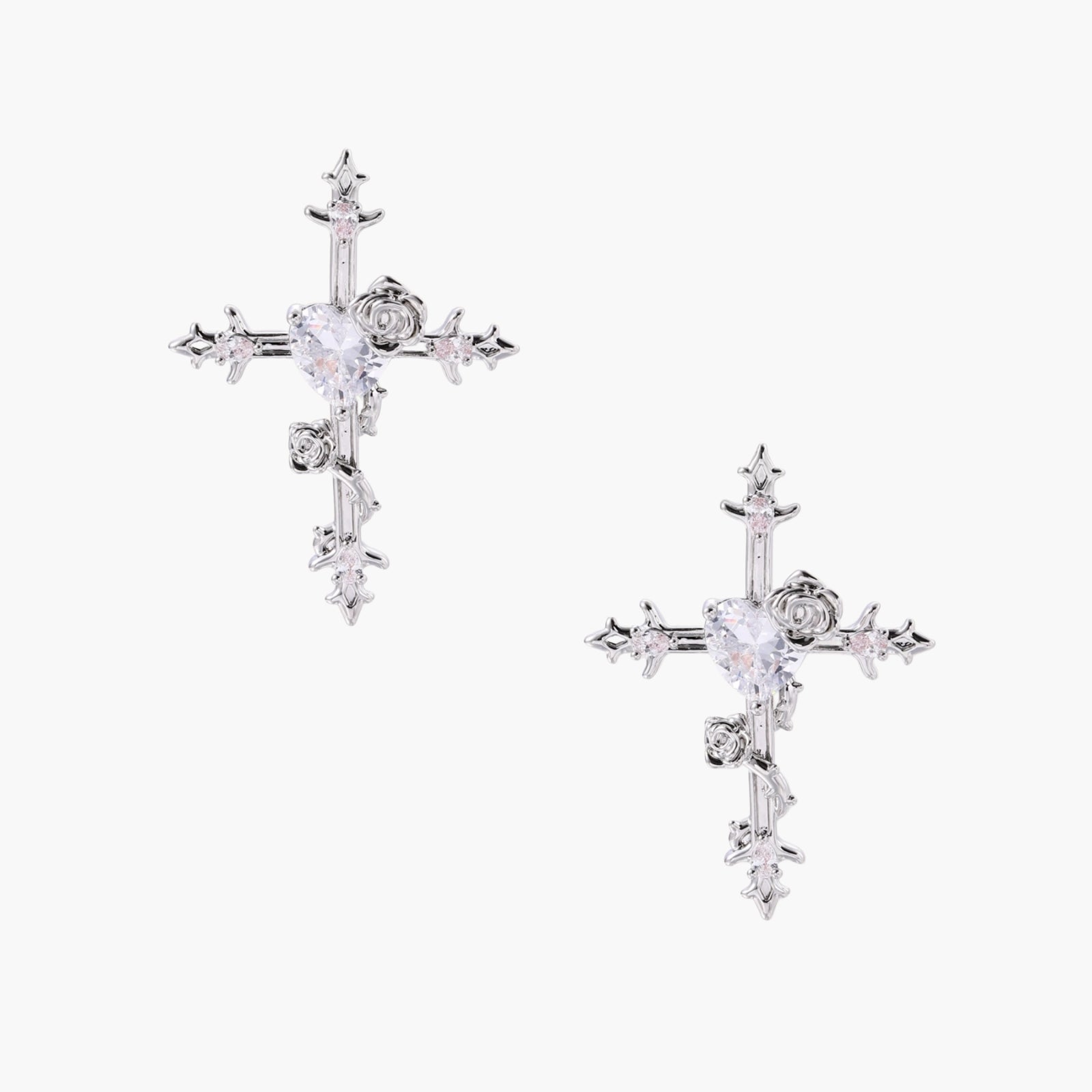 Ornate gold-plated cross earrings with zirconia stones and rose details on neutral background.