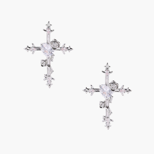 Ornate gold-plated cross earrings with zirconia stones and rose details on neutral background.