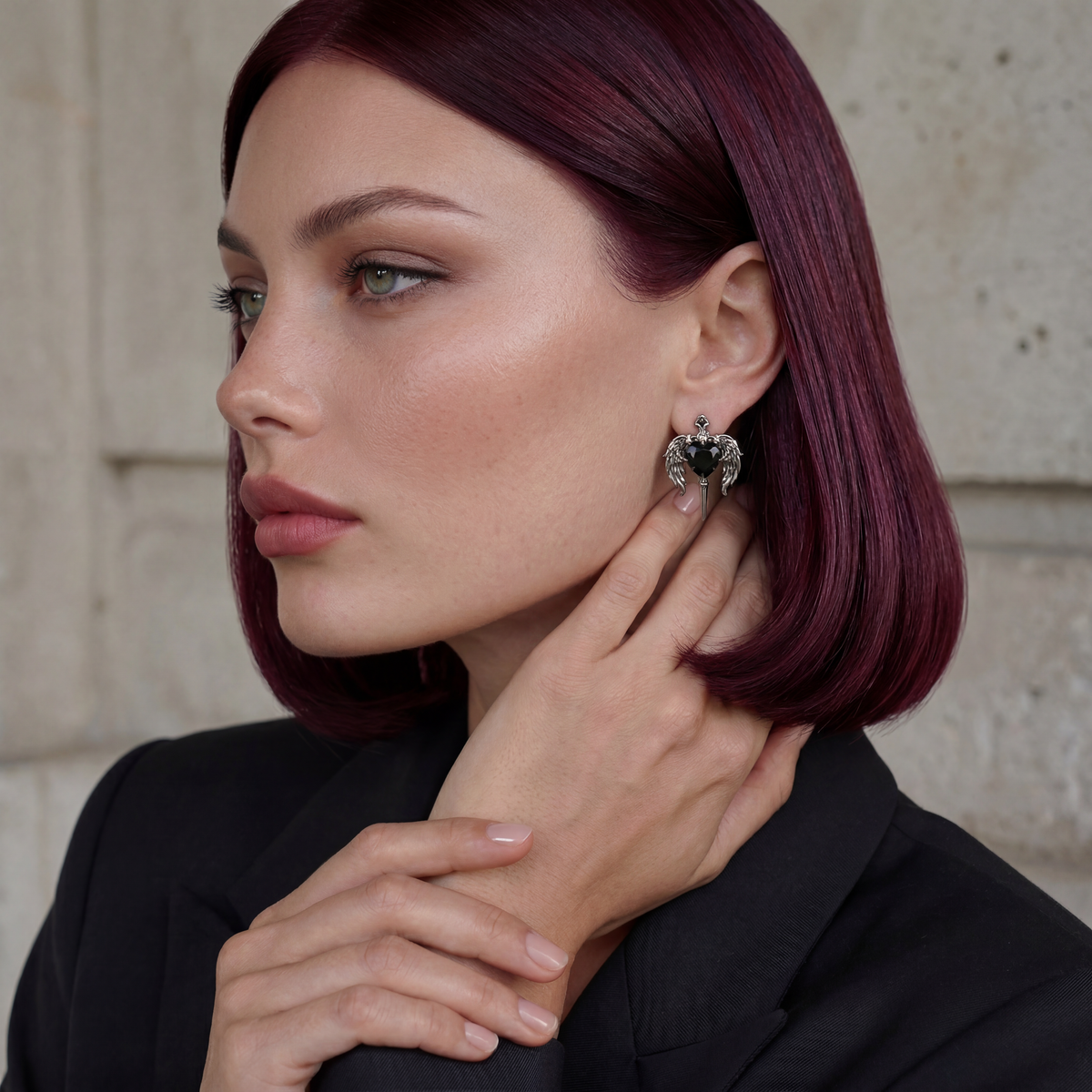 Woman with purple hair wearing a black earring against a neutral background